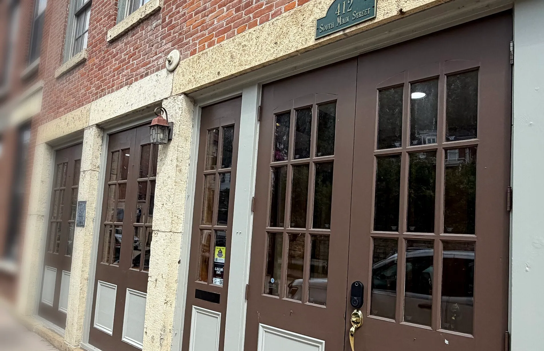 The Serenity storefront along South Main Street: brown-painted shopfront with divided-light doors, limestone piers and red brick above