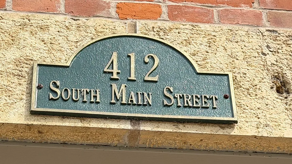 The cast address plaque on the limestone above the door, reading 412 South Main Street