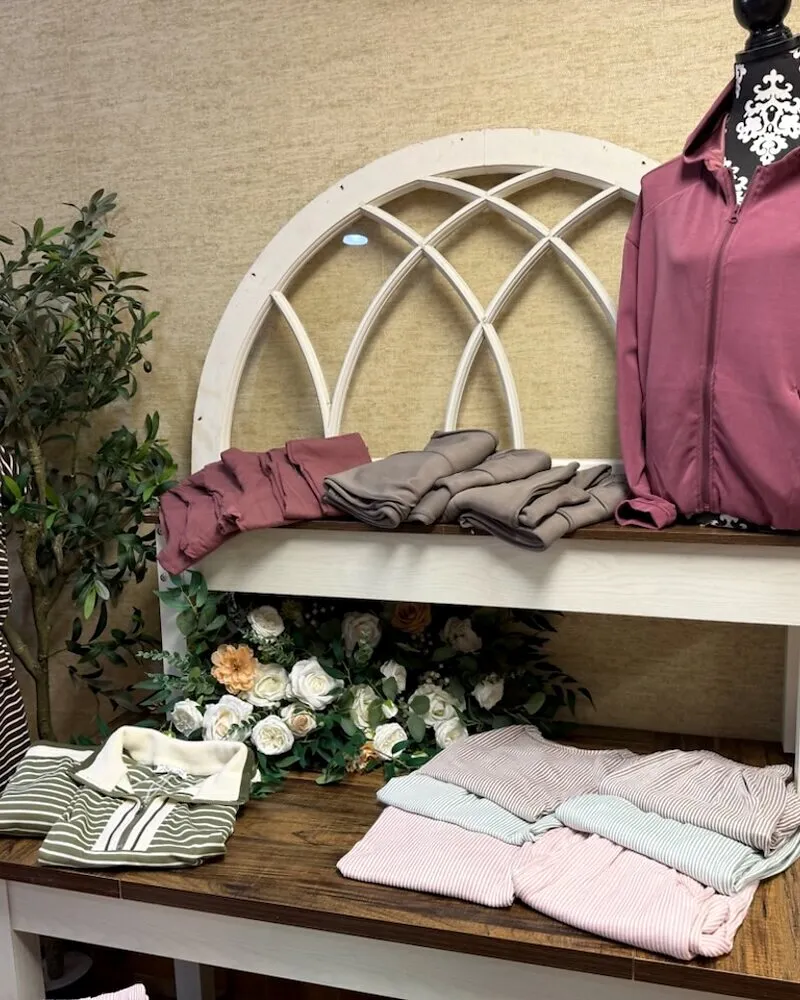Loungewear folded on the display table beneath the arched window frame