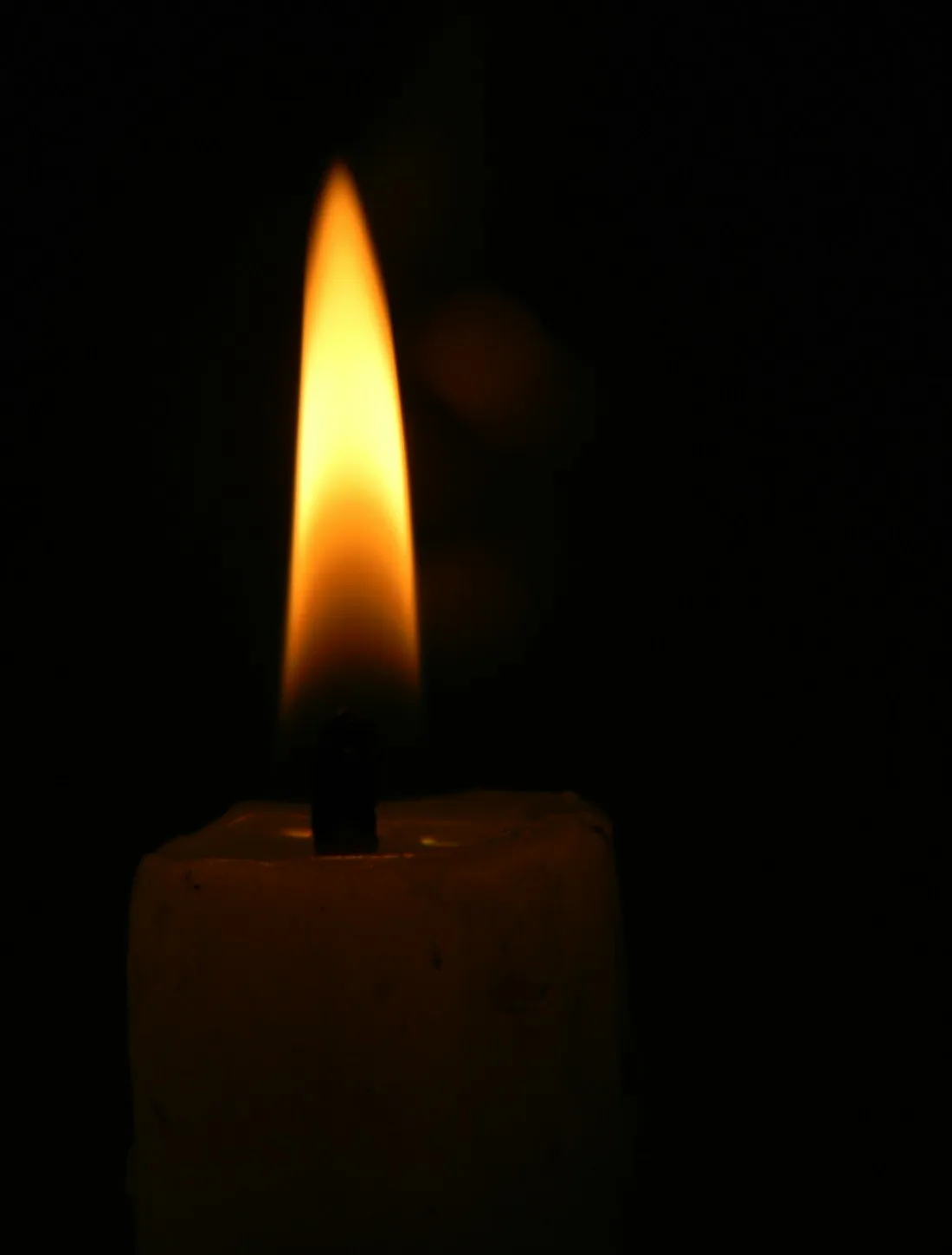 A lit candle in a dark room